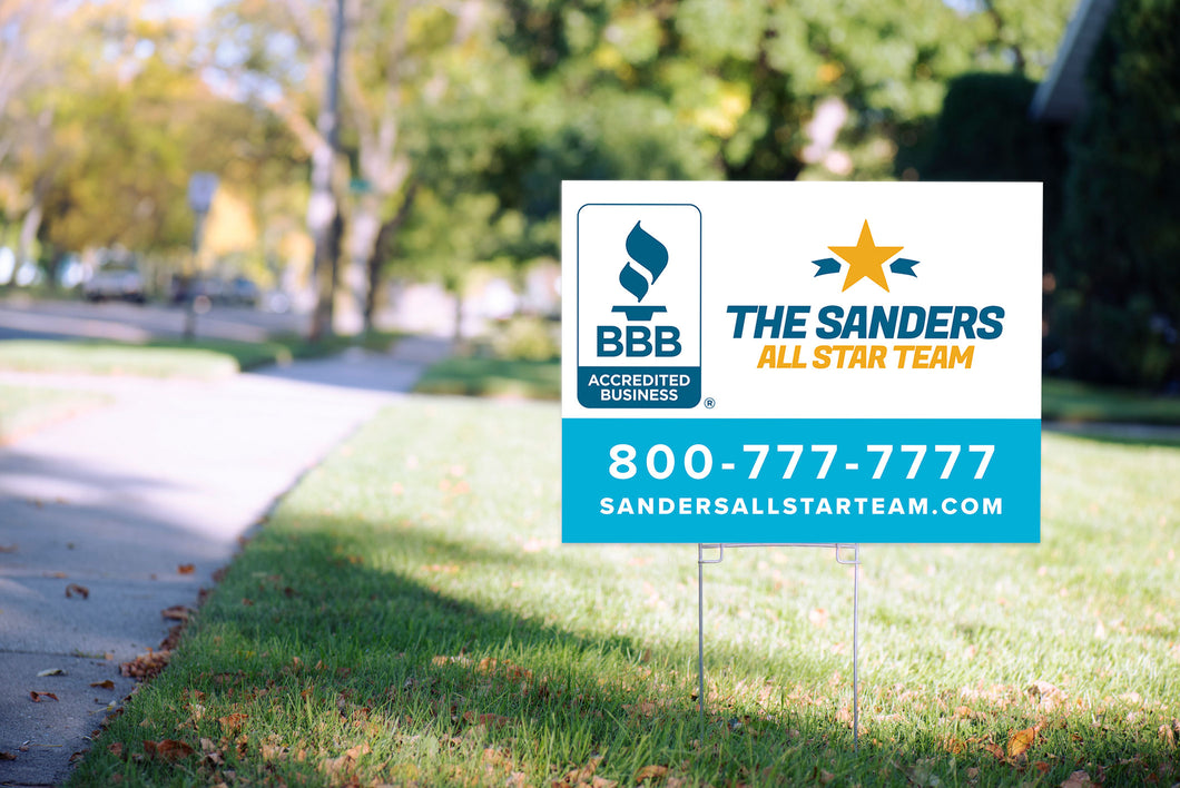 Sample white and blue yard sign with metal stake in lawn, with sidewalk, street as background