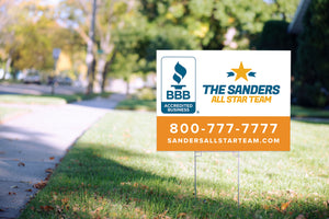 Sample white and orange yard sign with metal stake in lawn, with sidewalk, street as background