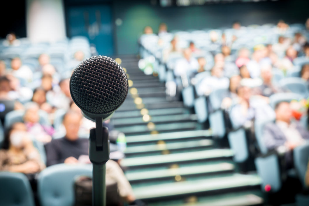 Microphone with conference room and people blurred in the background